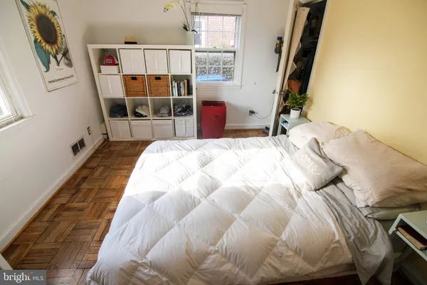 a bedroom with a bed a mirror and on the dresser