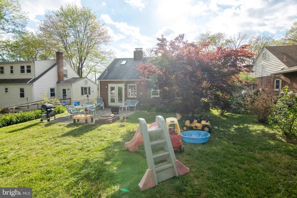 a backyard of a house with dining table and chairs