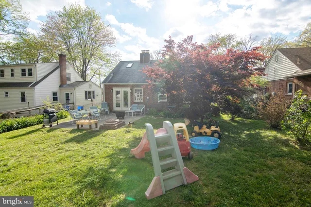 a backyard of a house with dining table and chairs