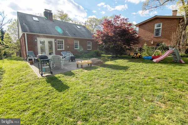 a backyard of a house with plants and large trees