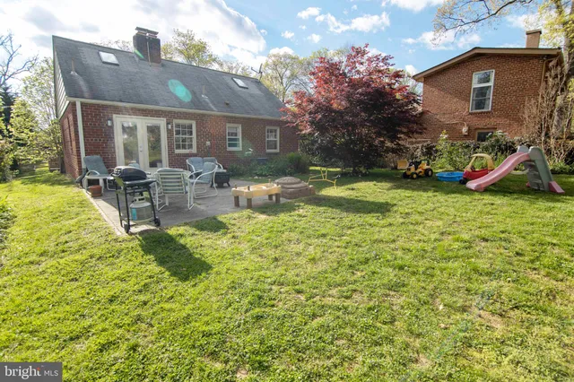 a backyard of a house with plants and large trees
