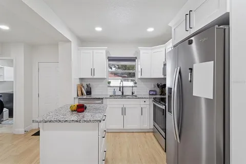 a kitchen with stainless steel appliances granite countertop a refrigerator and a sink