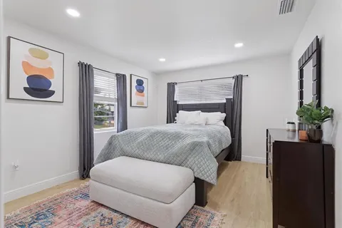 a bedroom with a bed and a potted plant