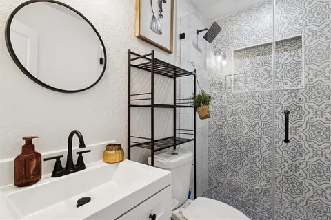 a bathroom with a sink mirror toilet and shower