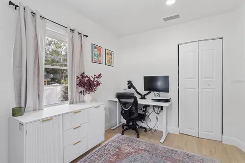 a view of a workspace with furniture and a window