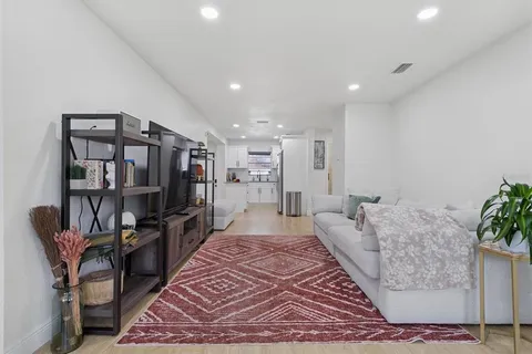 a living room with furniture and a book shelf