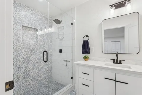 a bathroom with a shower sink and mirror