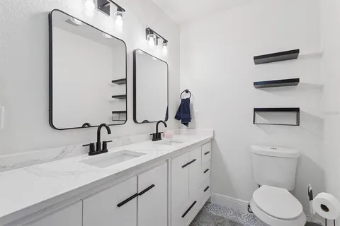 a bathroom with a toilet sink and mirror