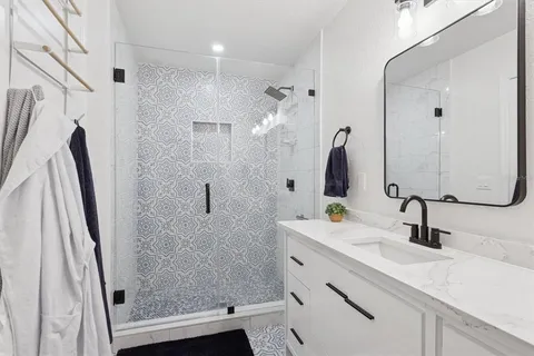 a bathroom with a shower sink and mirror