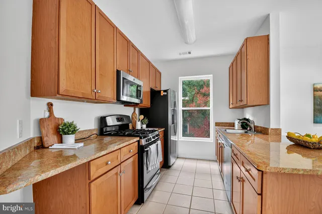 a kitchen with stainless steel appliances granite countertop a sink stove and cabinets