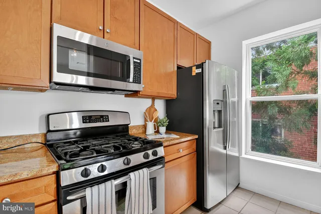 a kitchen with stainless steel appliances a stove a microwave and a sink