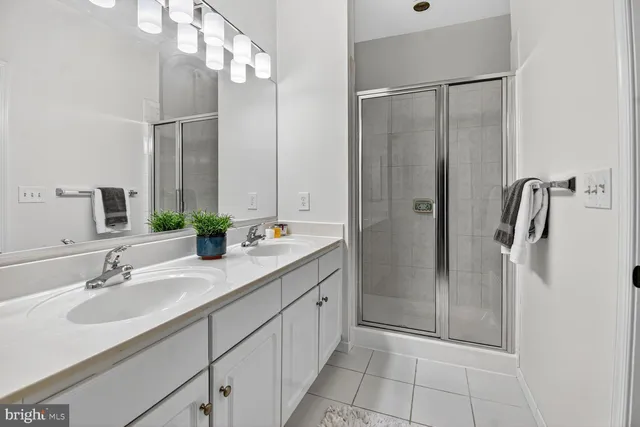 a bathroom with a double vanity sink mirror and shower