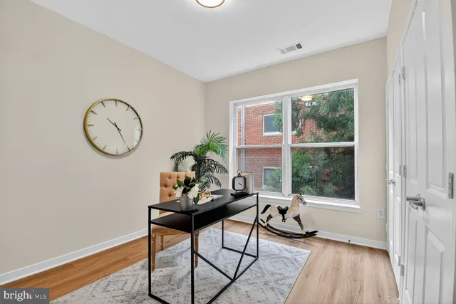 a living room with furniture a window and a potted plant