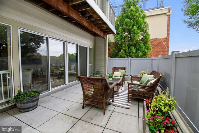 a view of a patio with table and chairs with wooden fence and plants
