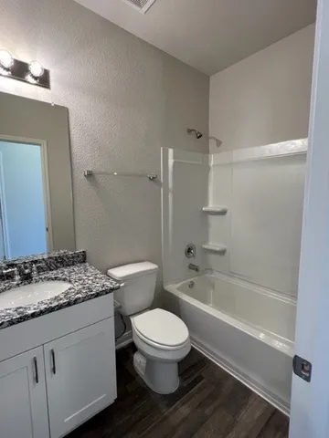 a bathroom with a granite countertop toilet sink and shower