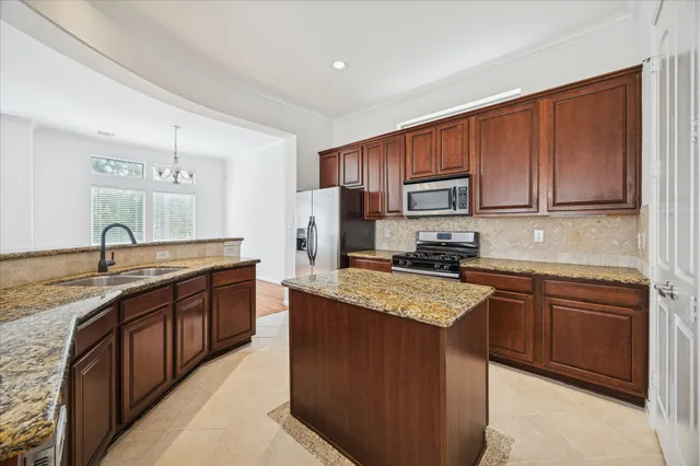 a kitchen with stainless steel appliances granite countertop a sink and a stove
