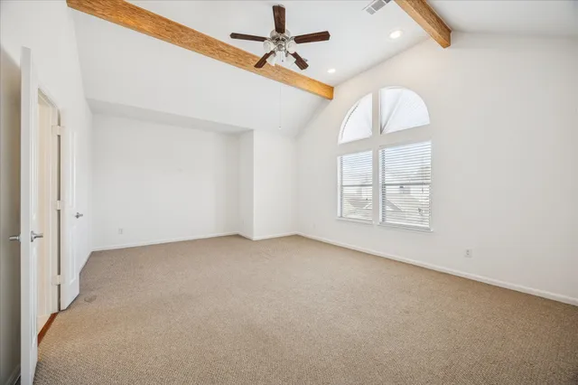 an empty room with windows and ceiling fan