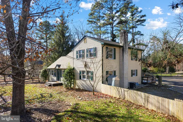 a front view of a house with a yard covered with snow and trees