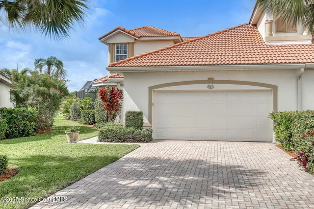 a front view of a house with plants