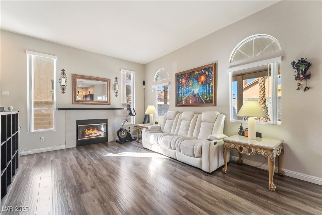 1081 Deep Well Court Henderson, NV 89011 - Photo 17 of 44 Living room with a tiled fireplace and wood finished floors