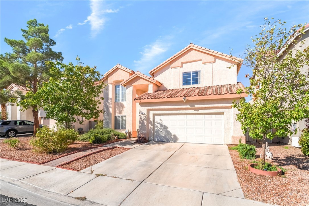 1081 Deep Well Court Henderson, NV 89011 - Photo 4 of 44 Mediterranean / spanish house with stucco siding, concrete driveway, a tiled roof, and a garage