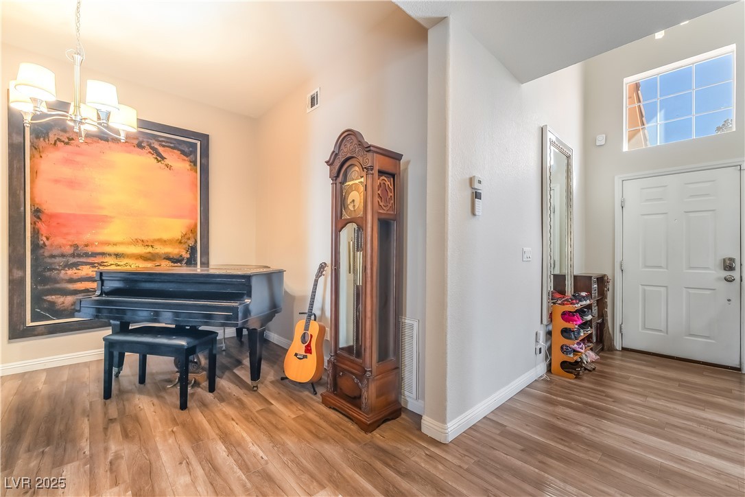 1081 Deep Well Court Henderson, NV 89011 - Photo 8 of 44 Foyer entrance with wood finished floors and a chandelier