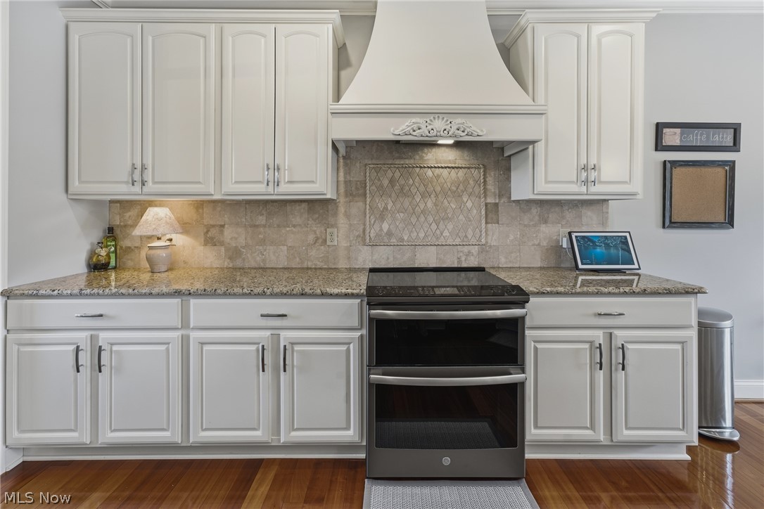 3955 Spring Brook Way Wooster, OH 44691 - Photo 10 of 50 White cabinetry with crown molding, stone countertops, tiled backsplash, and stainless steel double range