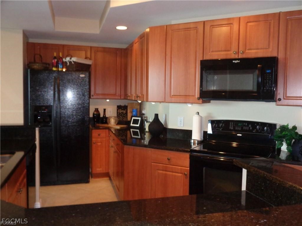 2743 First Street, Unit 1504 Fort Myers, FL 33916 - Photo 39 of 40 a kitchen with stainless steel appliances granite countertop a stove a refrigerator and a microwave