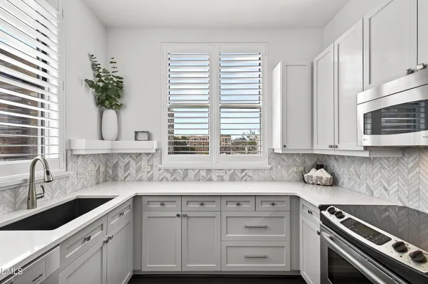 a kitchen with stainless steel appliances kitchen island granite countertop a refrigerator stove and microwave