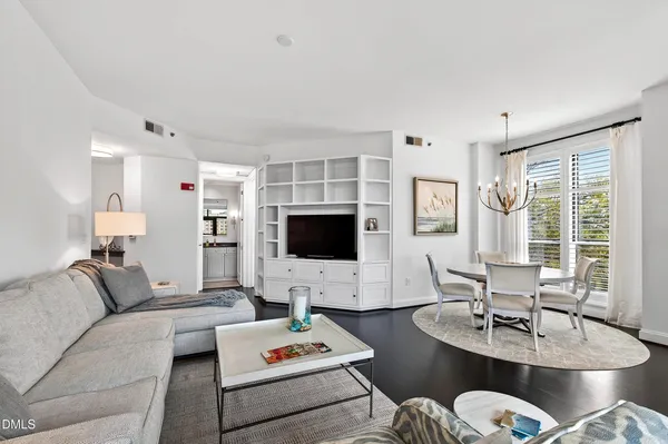 a living room with furniture a flat screen tv and a large window