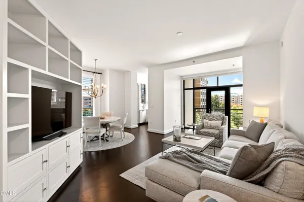a living room with furniture flat screen tv and large window