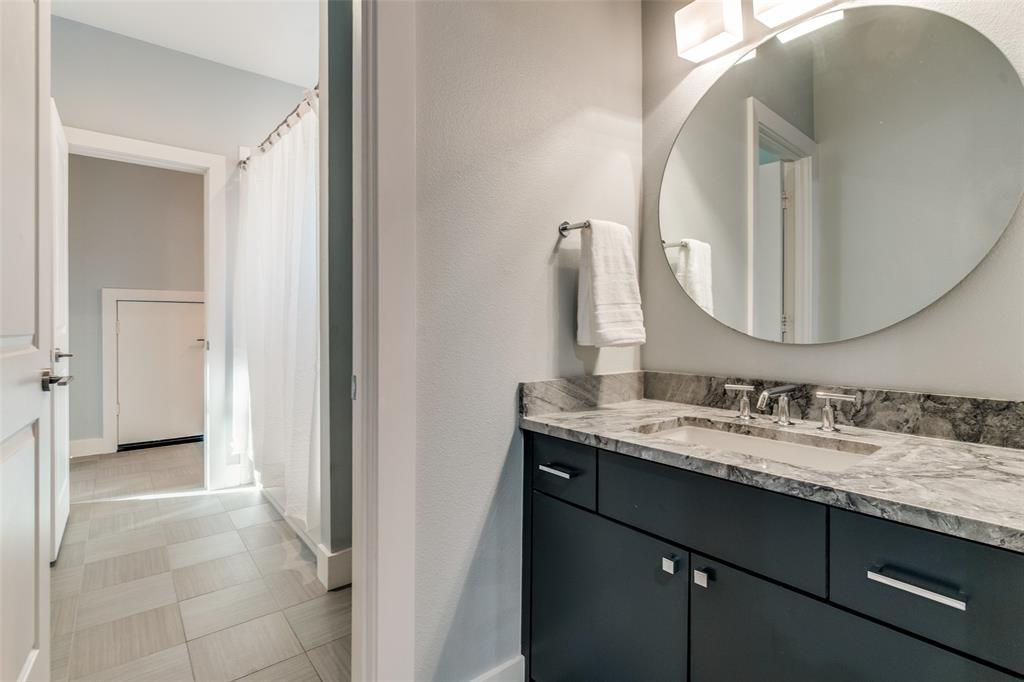 7912 Hanover Street Dallas, TX 75225 - Photo 13 of 29 Bathroom vanity featuring a vessel sink with chrome fixtures, a stone-finish countertop, and dark cabinetry with rectangular hardware