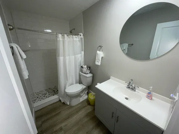 a bathroom with a sink a toilet and shower