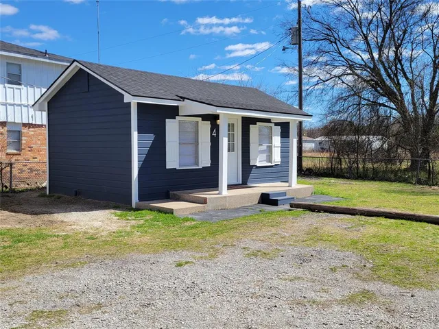 a view of a house with a yard patio and a floor to ceiling window