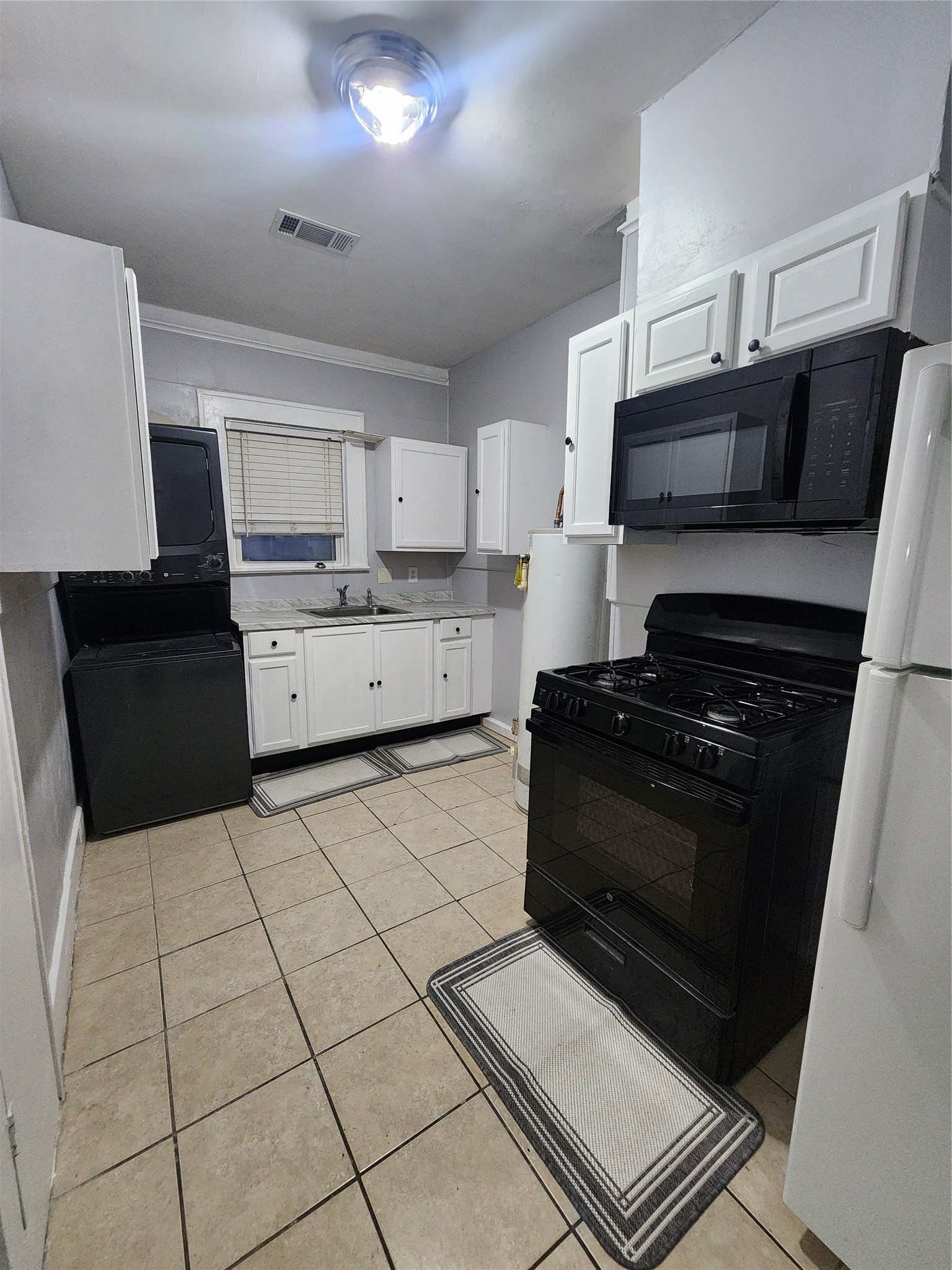 2504 Isabella Street Houston, TX 77004 - Photo 8 of 13 a kitchen with a stove a sink and a microwave