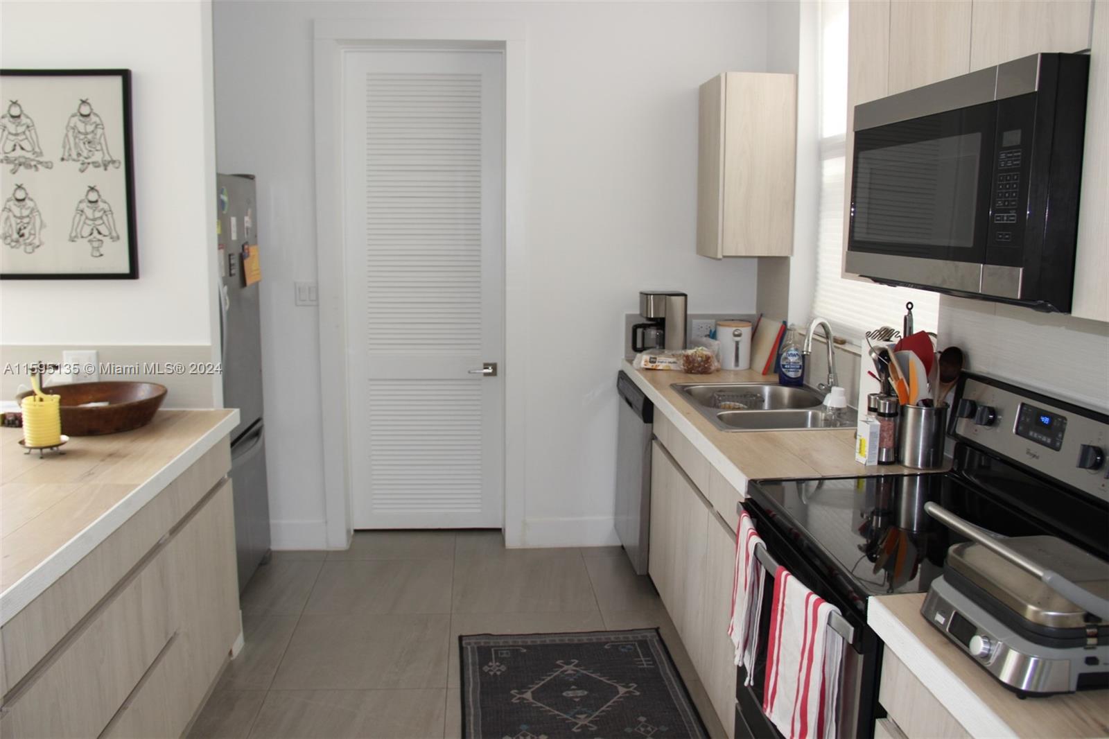 2944 Southwest 27th Terrace, Unit 2944 Miami, FL 33133 - Photo 13 of 44 a kitchen with stainless steel appliances granite countertop a sink stove and refrigerator