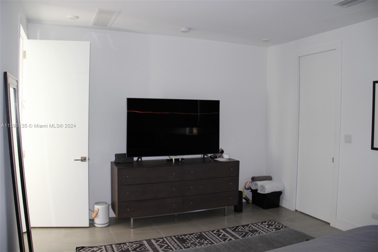 2944 Southwest 27th Terrace, Unit 2944 Miami, FL 33133 - Photo 32 of 44 a room with wooden floor and furniture