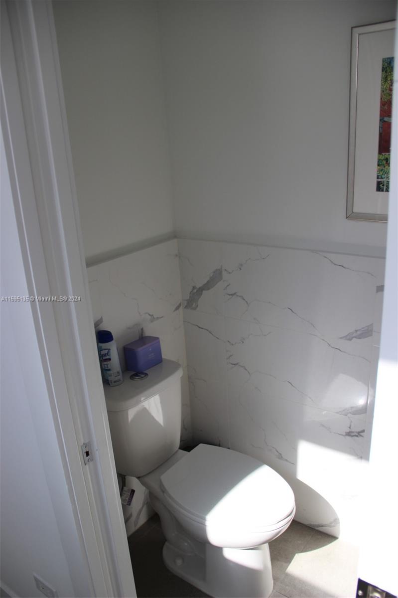 2944 Southwest 27th Terrace, Unit 2944 Miami, FL 33133 - Photo 10 of 44 a white toilet sitting next to a bathroom sink and vanity
