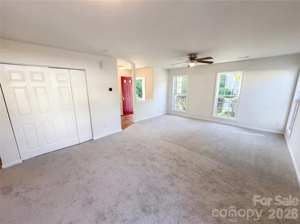an empty room with windows and cabinet
