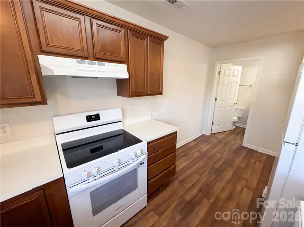 a kitchen with wooden floor and cabinets
