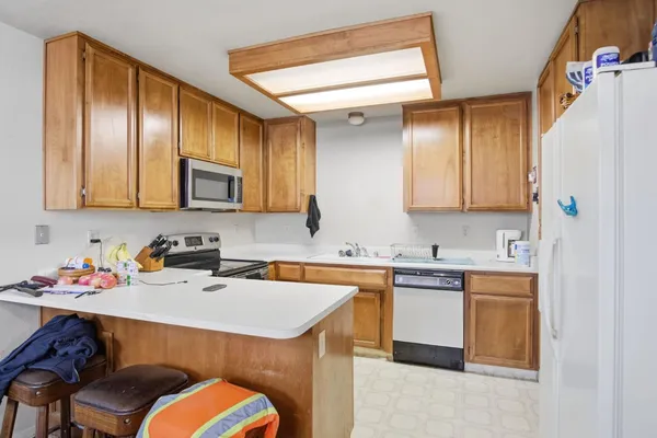 a kitchen with stainless steel appliances a sink a stove a refrigerator and cabinets
