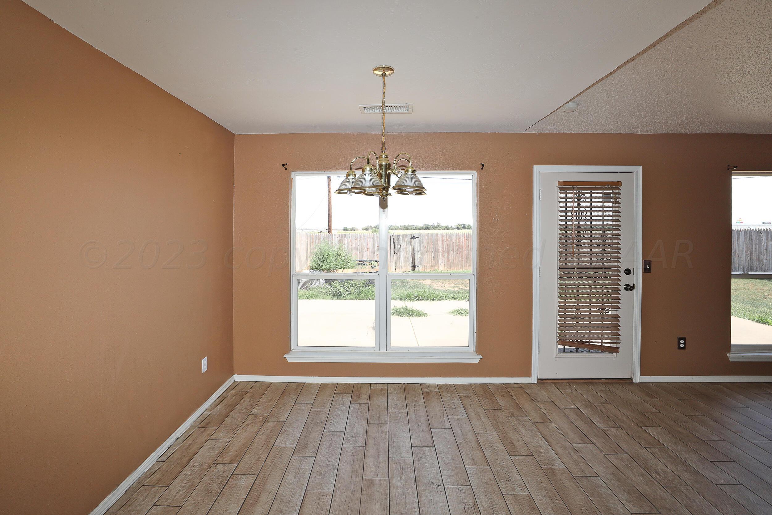 1025 Ketler Street Amarillo, TX 79104 - Photo 12 of 29 a view of an empty room with wooden floor and a window