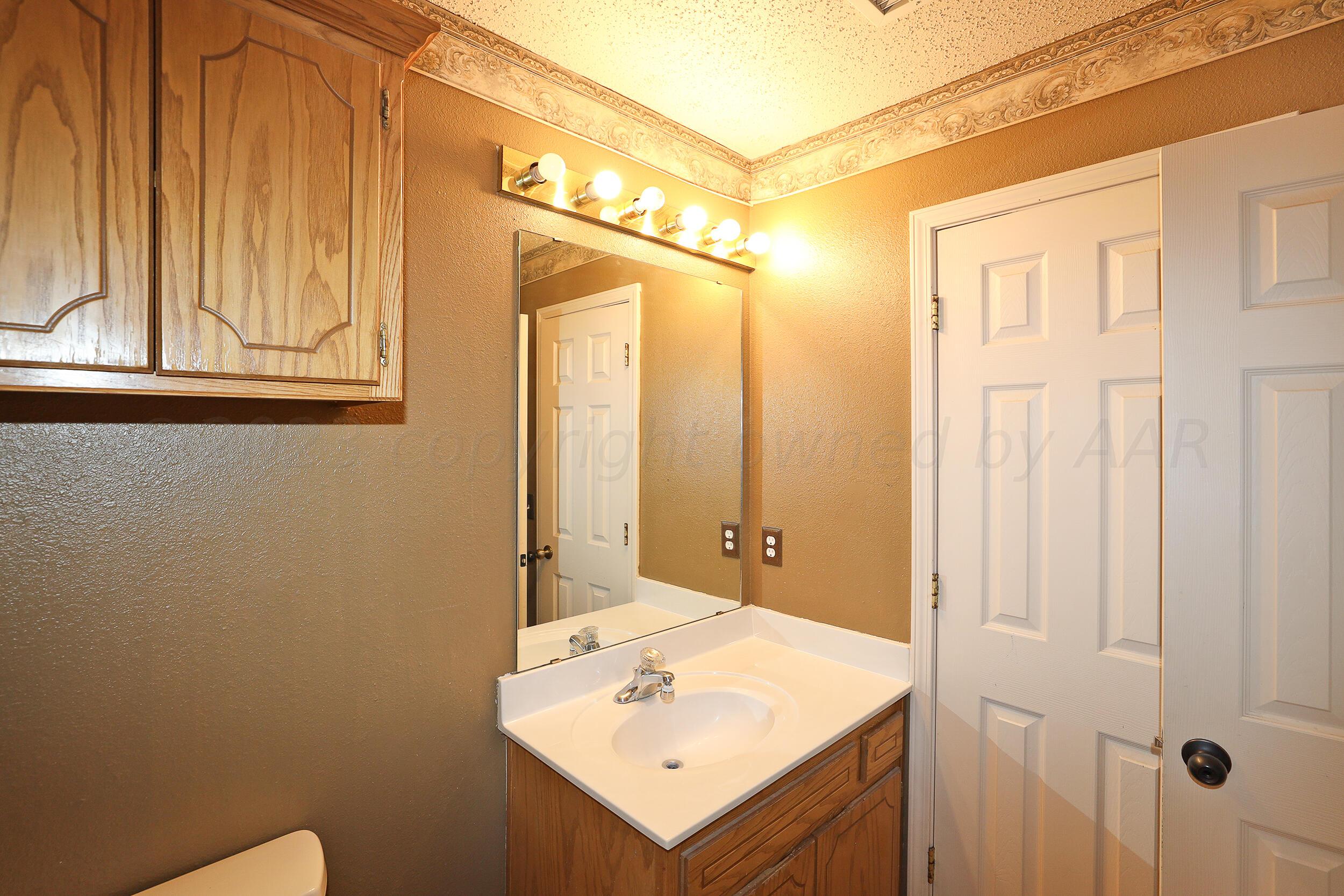 1025 Ketler Street Amarillo, TX 79104 - Photo 16 of 29 a bathroom with a sink a mirror and a shower