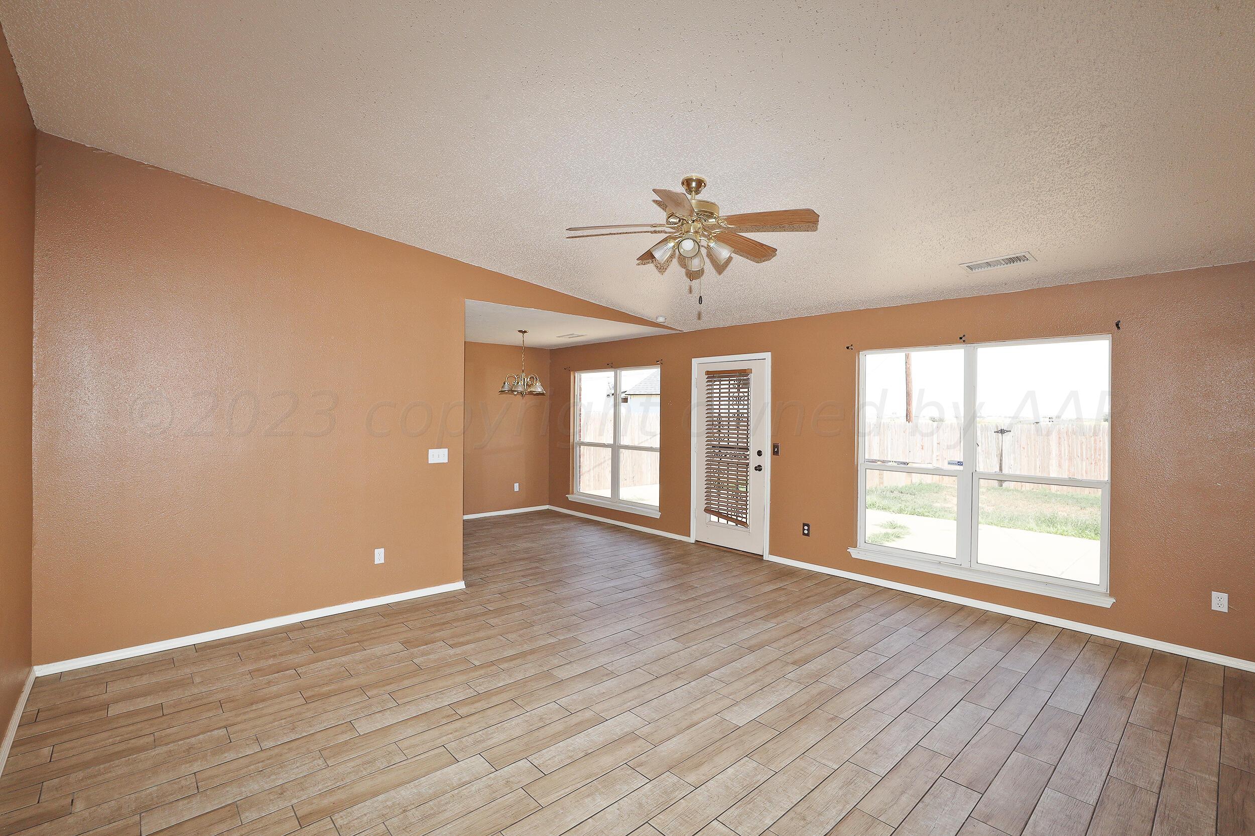 1025 Ketler Street Amarillo, TX 79104 - Photo 5 of 29 an empty room with wooden floor and windows