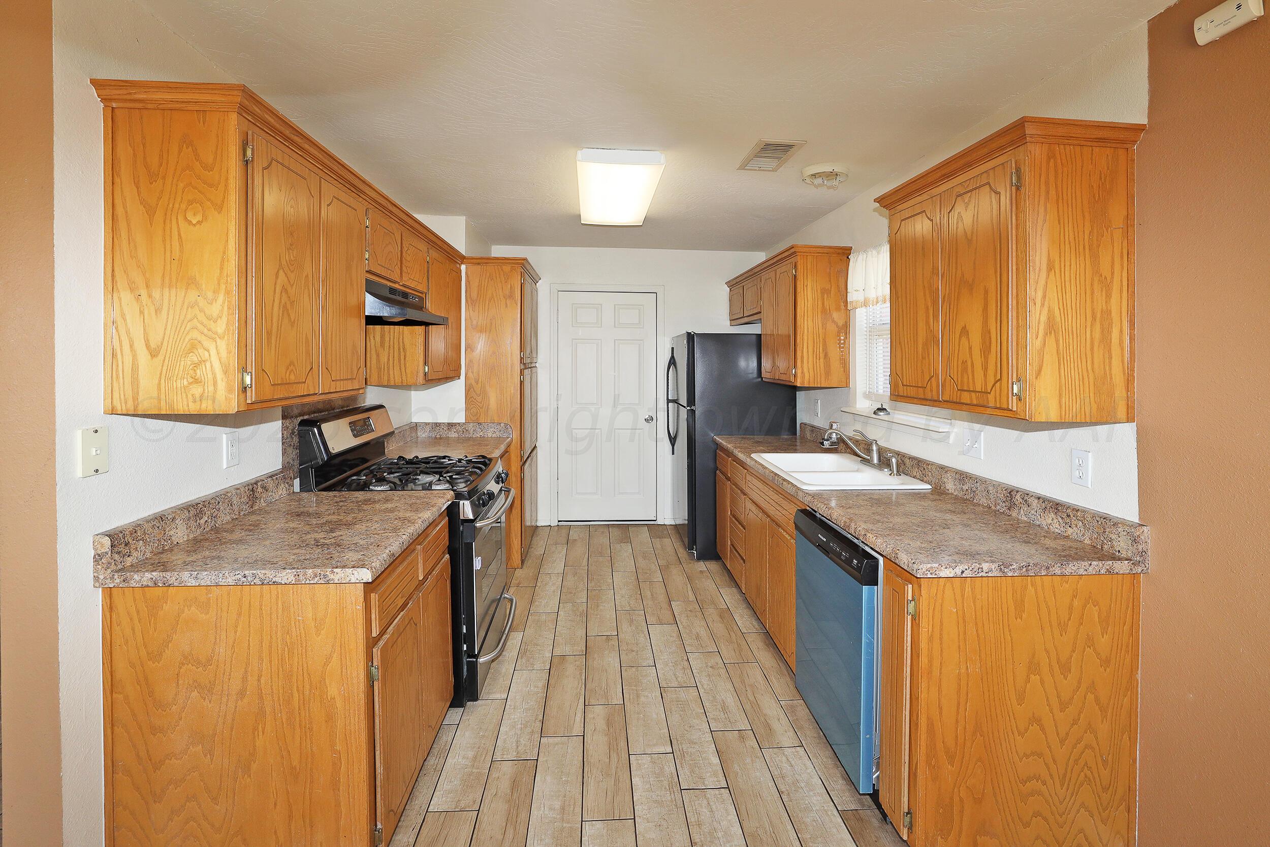 1025 Ketler Street Amarillo, TX 79104 - Photo 8 of 29 a kitchen with a sink stove top oven and cabinets