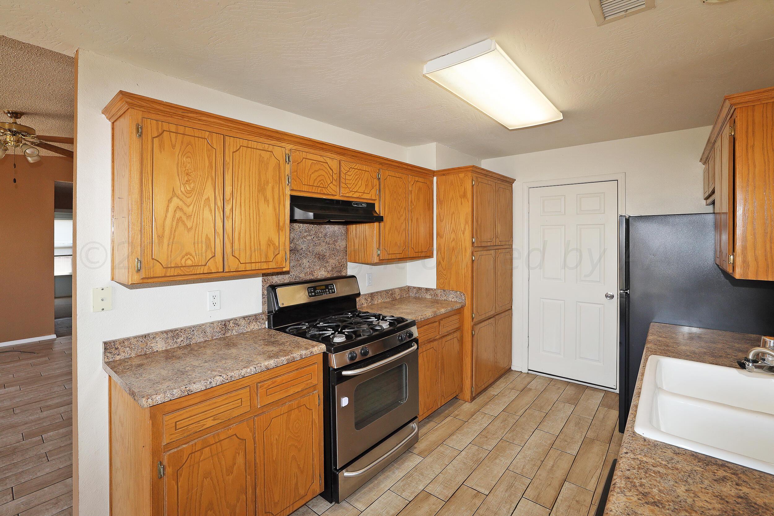 1025 Ketler Street Amarillo, TX 79104 - Photo 9 of 29 a kitchen with granite countertop a stove and a refrigerator
