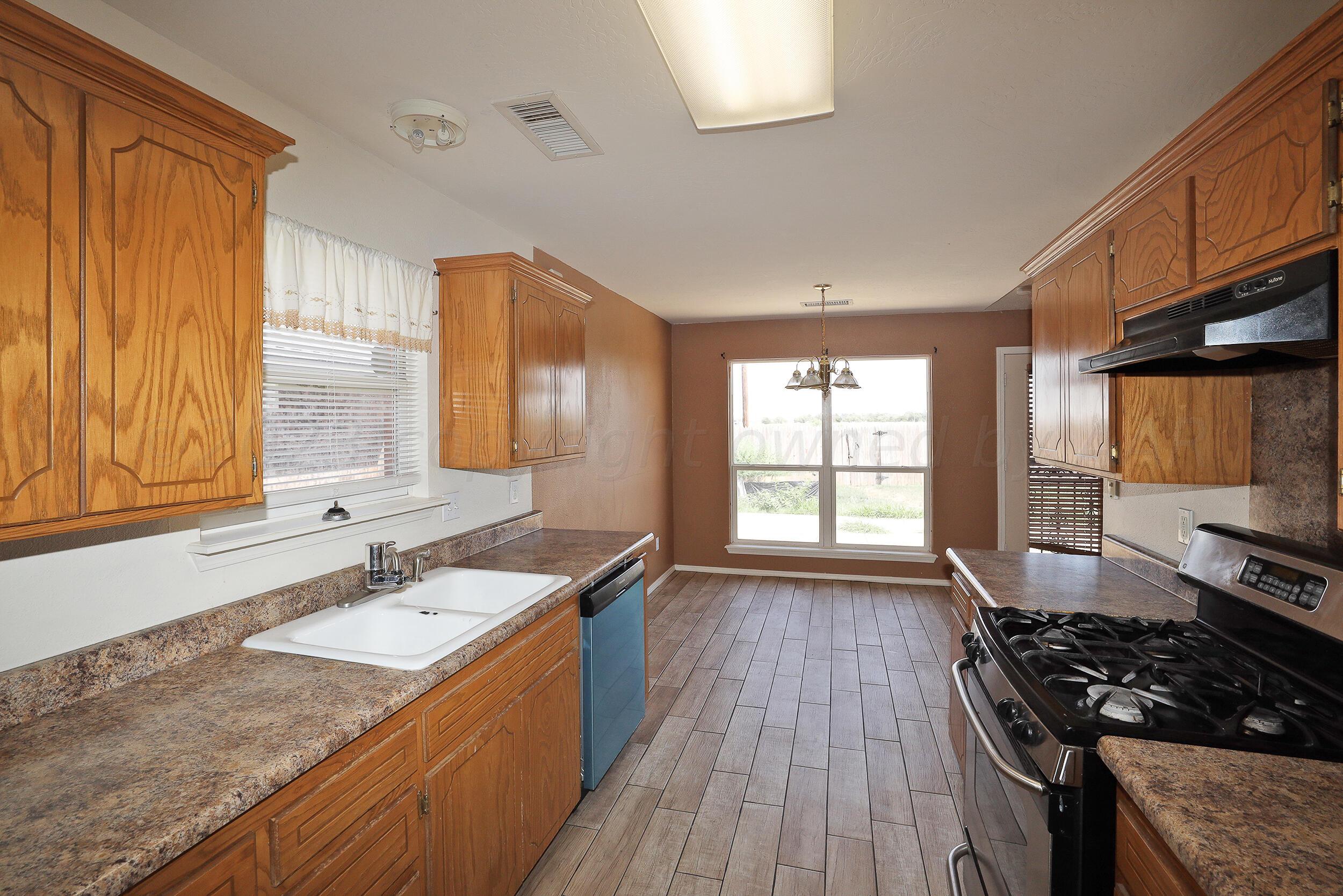 1025 Ketler Street Amarillo, TX 79104 - Photo 10 of 29 a kitchen with granite countertop a sink stove and cabinets