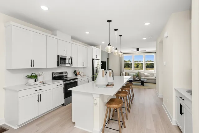 a kitchen with a sink a stove cabinets and wooden floor