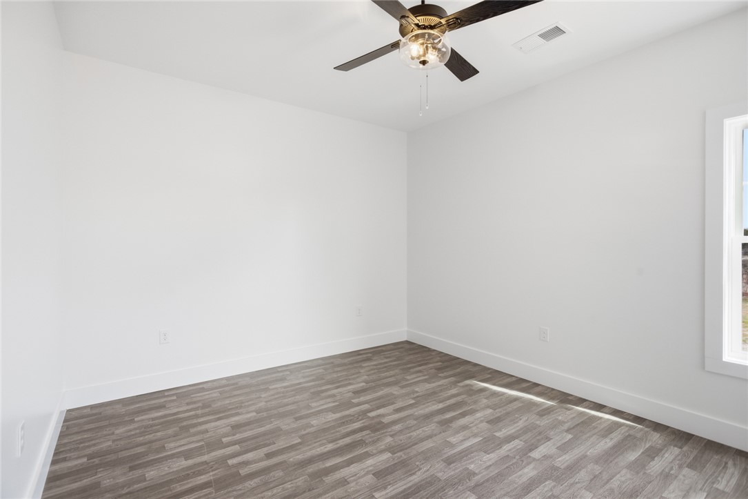 115 Riley Street Westminster, SC 29693 - Photo 12 of 46 This bright bedroom features durable flooring and a refreshing ceiling fan, ready for personal touches.