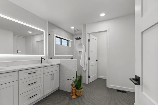 a bathroom with a double sink shower and a mirror